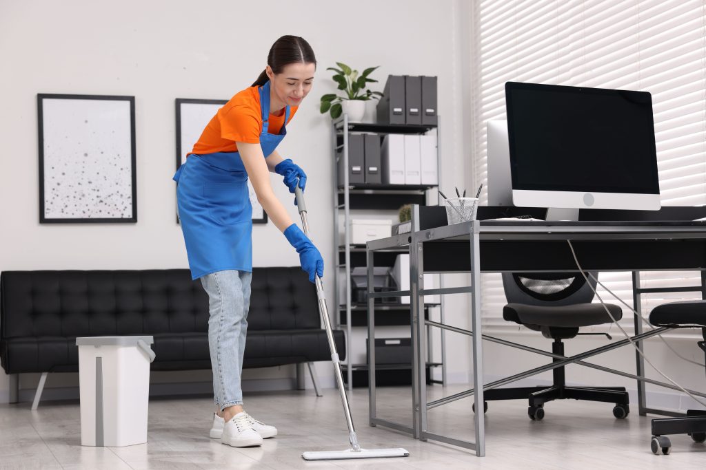 cleaning service. woman washing floor with mop in office